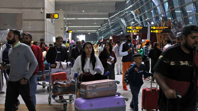 Travellers push carts with their luggage at the departure area of Terminal 3 at Indira Gandhi International Airport in New Delhi