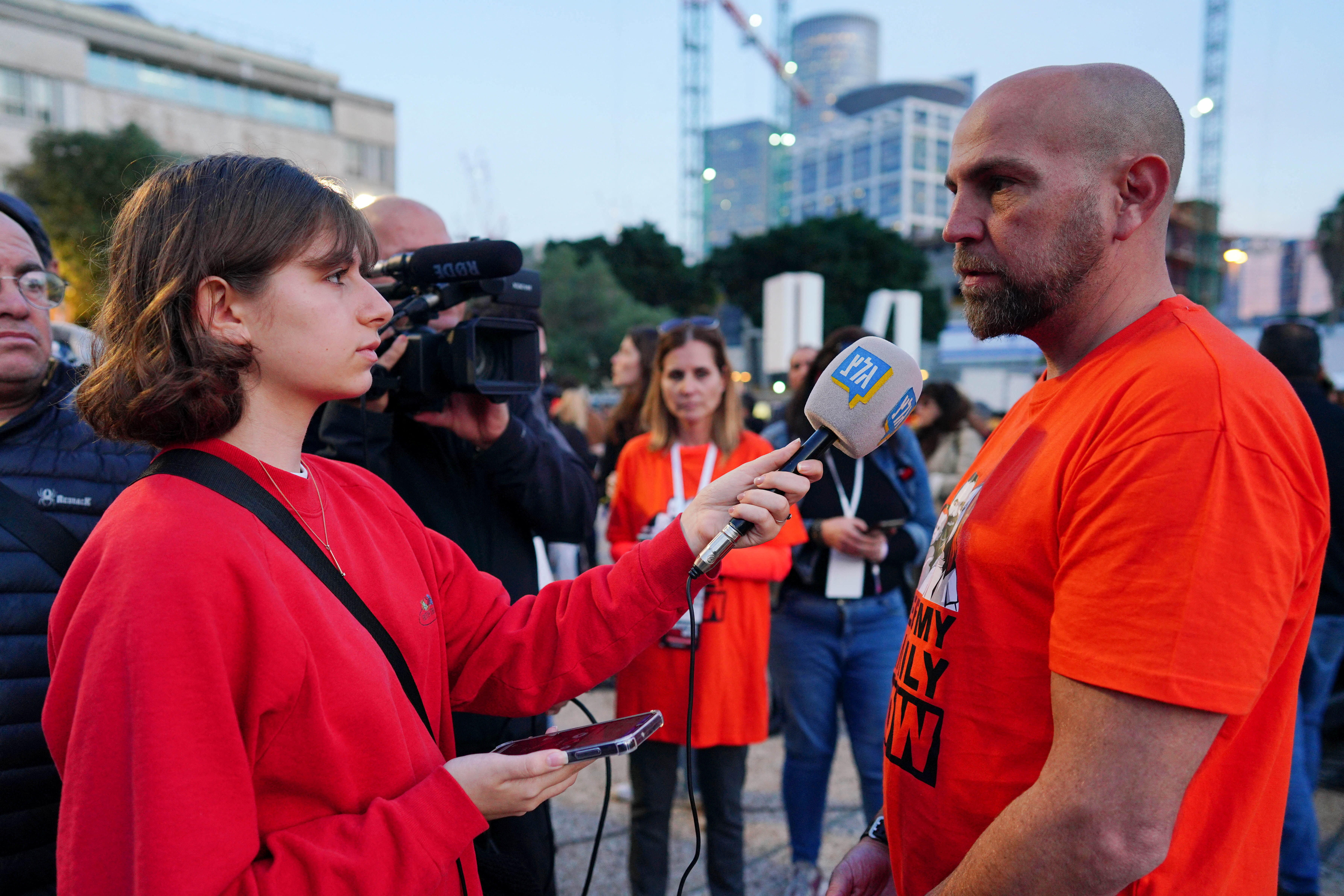 Shira Sheffi from Israel's Army Radio interviews a relative of Kfir Bibas, in Tel Aviv