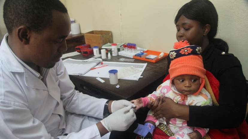 FILE PHOTO: A doctor tests a child for malaria at the Ithani-Asheri Hospital in Arusha, Tanzania