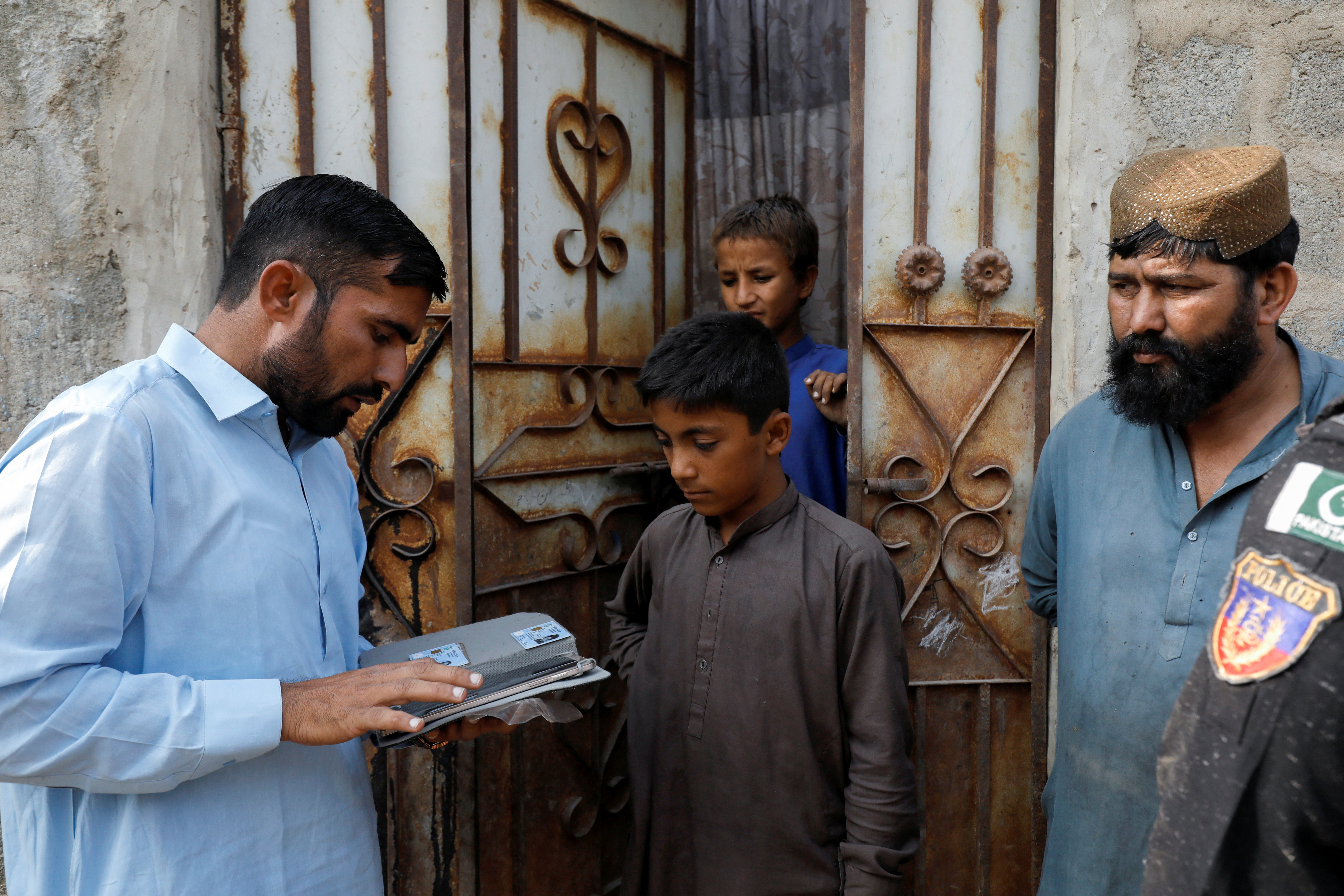Police conduct a search and verification drive for undocumented Afghan nationals, on the outskirts of Karachi