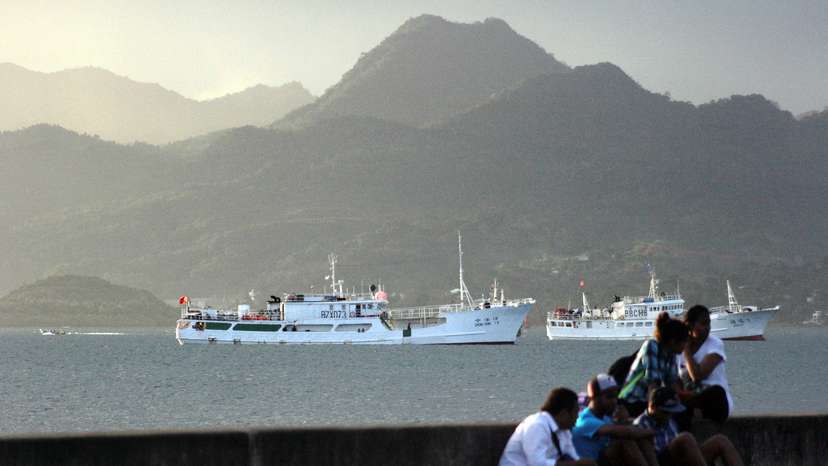 FILE PHOTO: Locals sit on a wall situated on the foreshore of the harbour in the Fiji capital of Suva