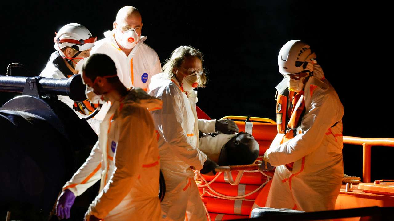 Rescuers disembark a migrant in critical condition from a Spanish coast guard vessel at the port of Arguineguin, on the island of Gran Canaria