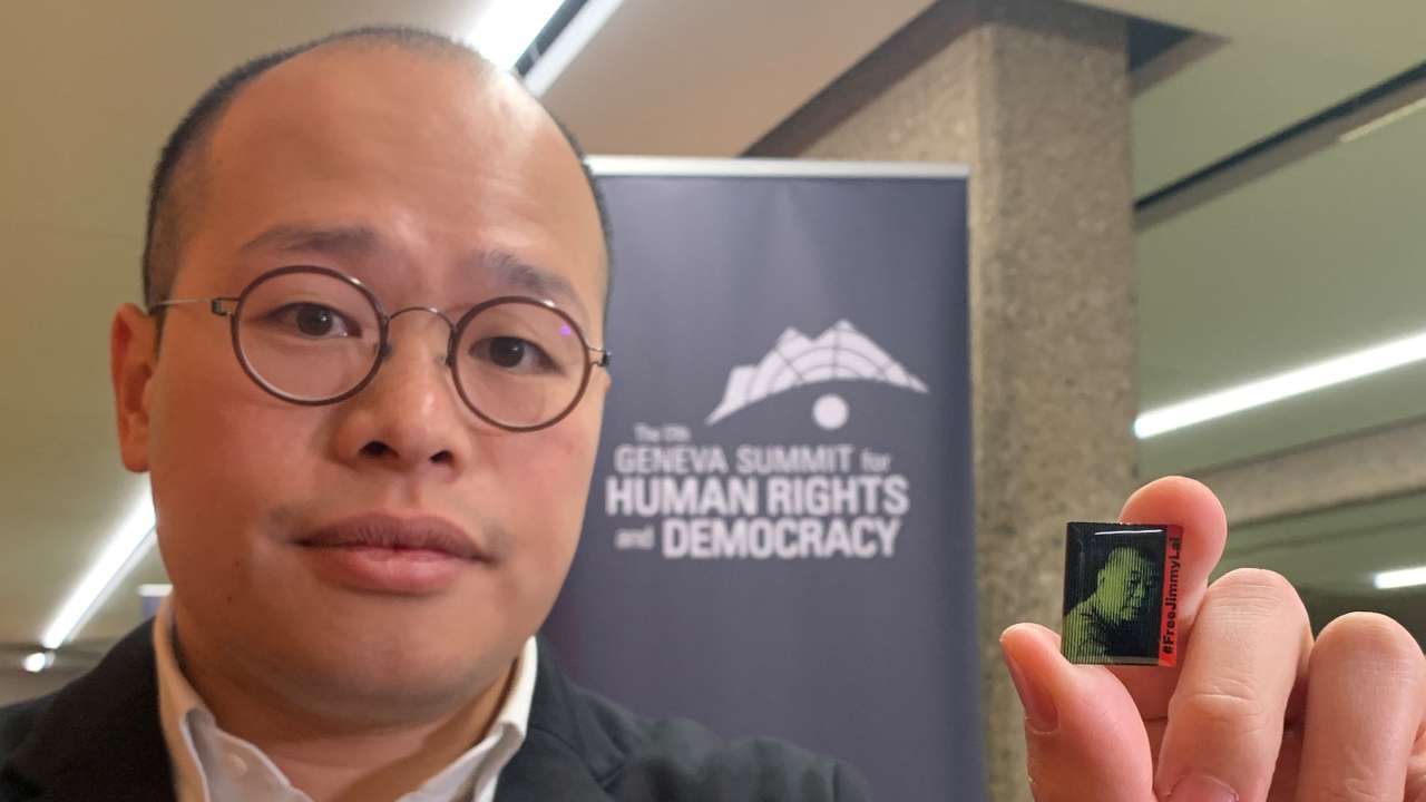 Sebastien Lei, the son of Hong Kong pro-democracy advocate Jimmy Lai, holds a pins with a portrait of his father in Geneva