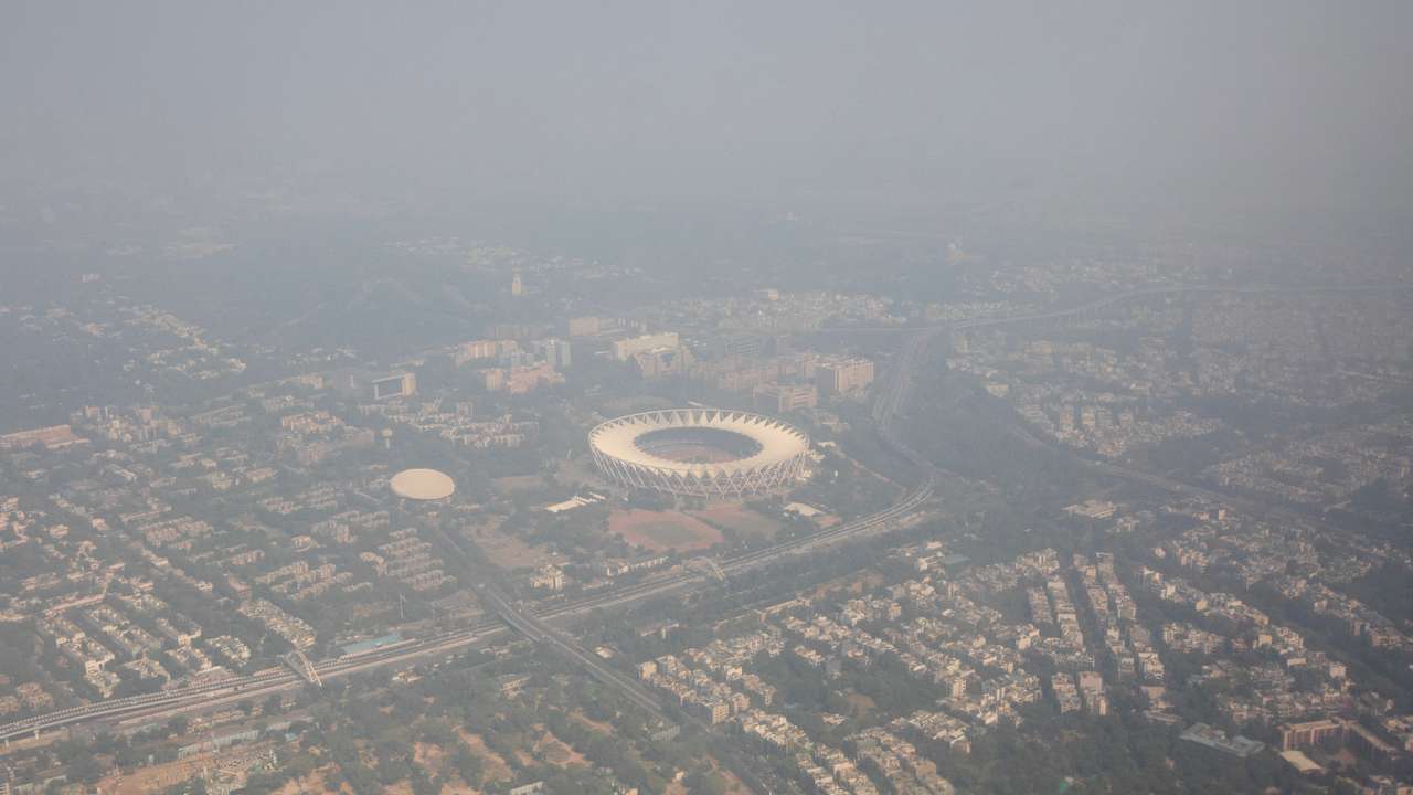 An aerial view shows residential buildings and a stadium shrouded in smog in New Delhi