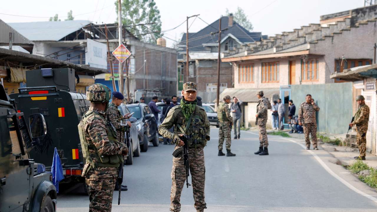 Indian security force personnel stand guard near the site of a fighter jet crash in Wuyan