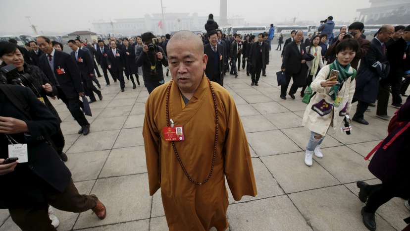 FILE PHOTO: Buddhist abbot Shi Yongxin, a delegate of the NPC, walks toward the Great Hall of the People in Beijing