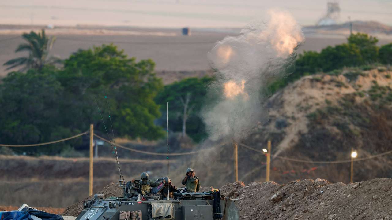 Israeli soldiers fire a mortar towards Gaza