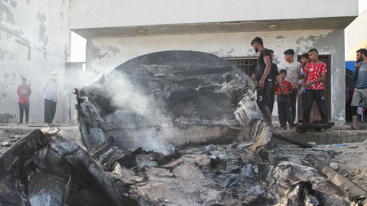 Palestinians inspect boats damaged in Israeli fire, in Rafah in the southern Gaza Strip