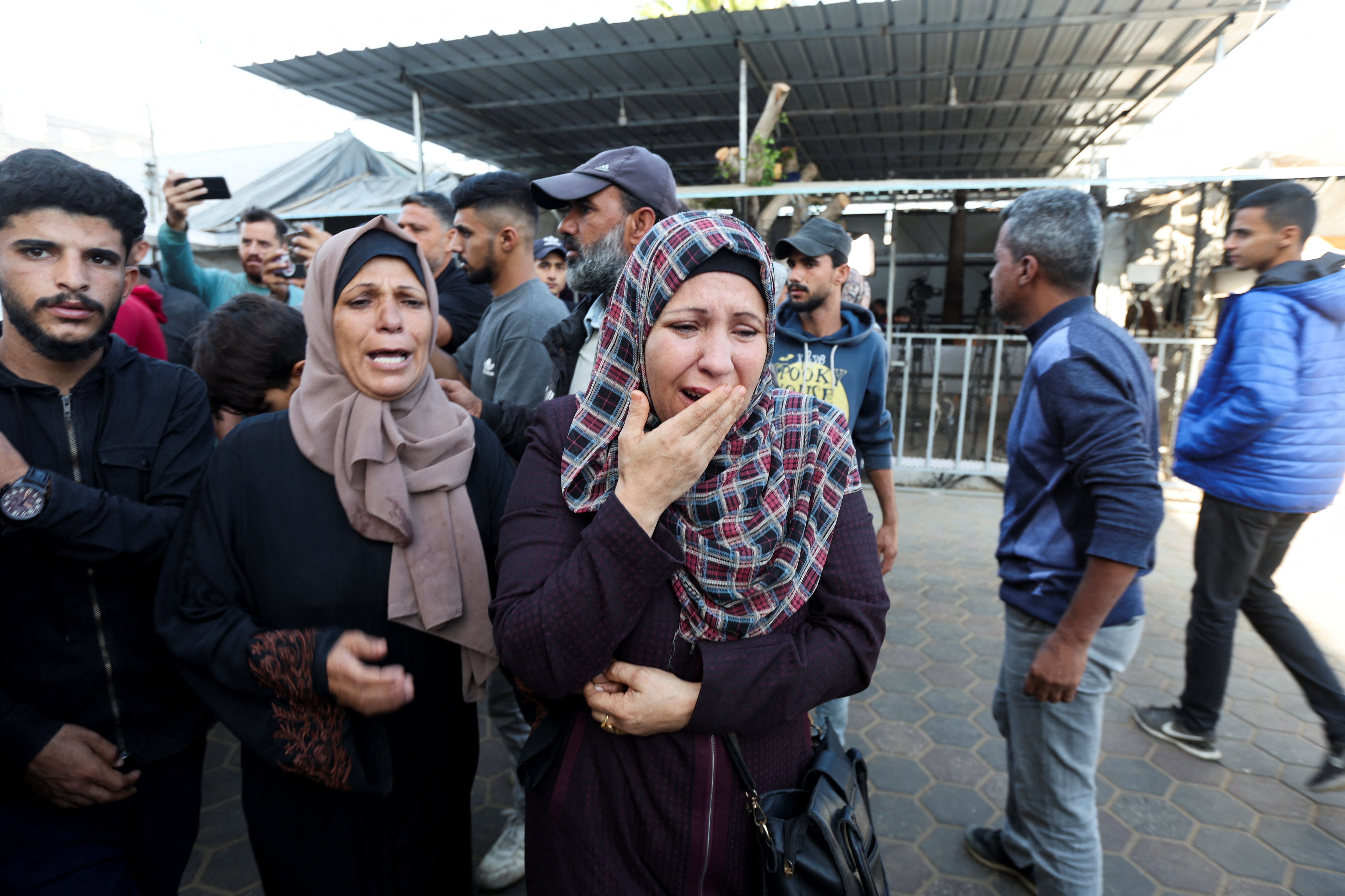 Palestinians mourn loved ones killed in Israeli strikes, in Deir Al-Balah, in the central Gaza Strip