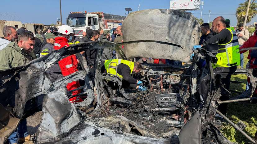 Members of civil defence inspect a damaged car after an Israeli strike, according to security sources, at the southern port city of Sidon