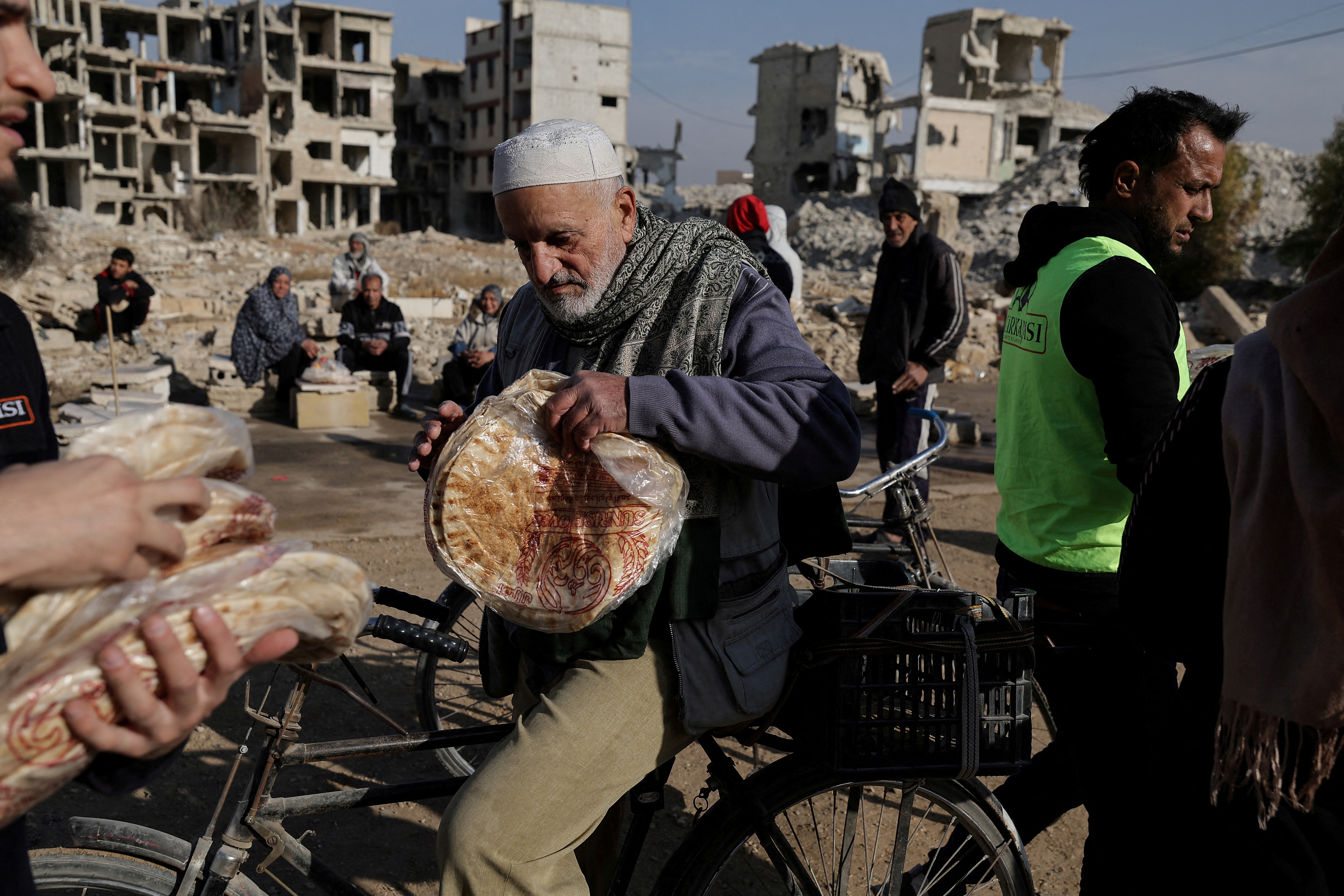FILE PHOTO: A man holds a bag of bread after he received it from Ecir Kapici, Turkish humanitarian NGO at al-Yarmouk Palestinian refugee camp, in Damascus