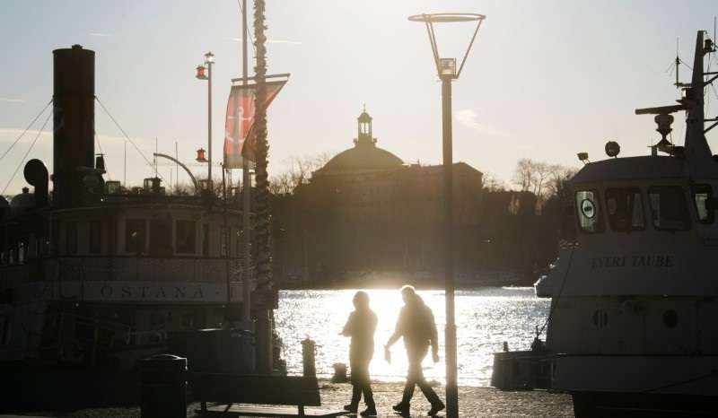 People stroll in the cold but sunny weather along Standvagen quayside, amid the continuous spread of the coronavirus disease (COVID-19) pandemic in Stockholm