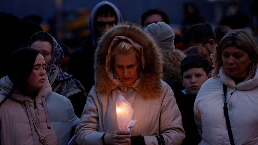 People gather at a makeshift memorial to the victims of a shooting attack at a concert hall outside Moscow