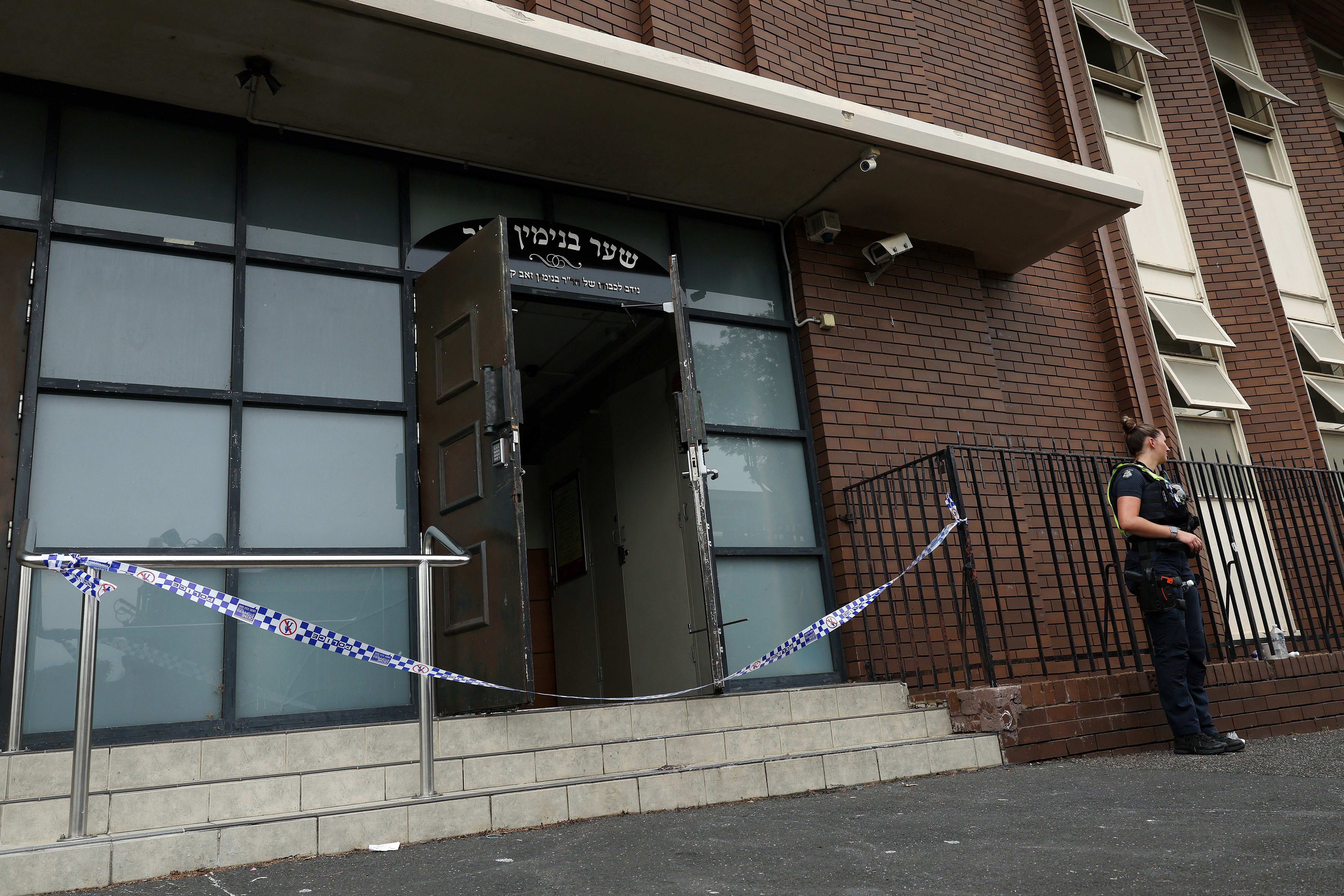 A policewoman stands guard at the scene of a fire at the Adass Israel Synagogue in Ripponlea