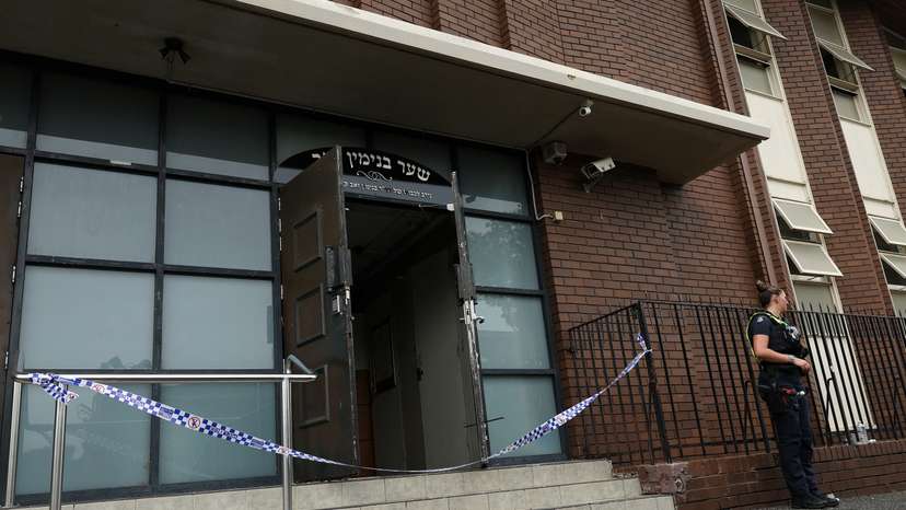 A policewoman stands guard at the scene of a fire at the Adass Israel Synagogue in Ripponlea
