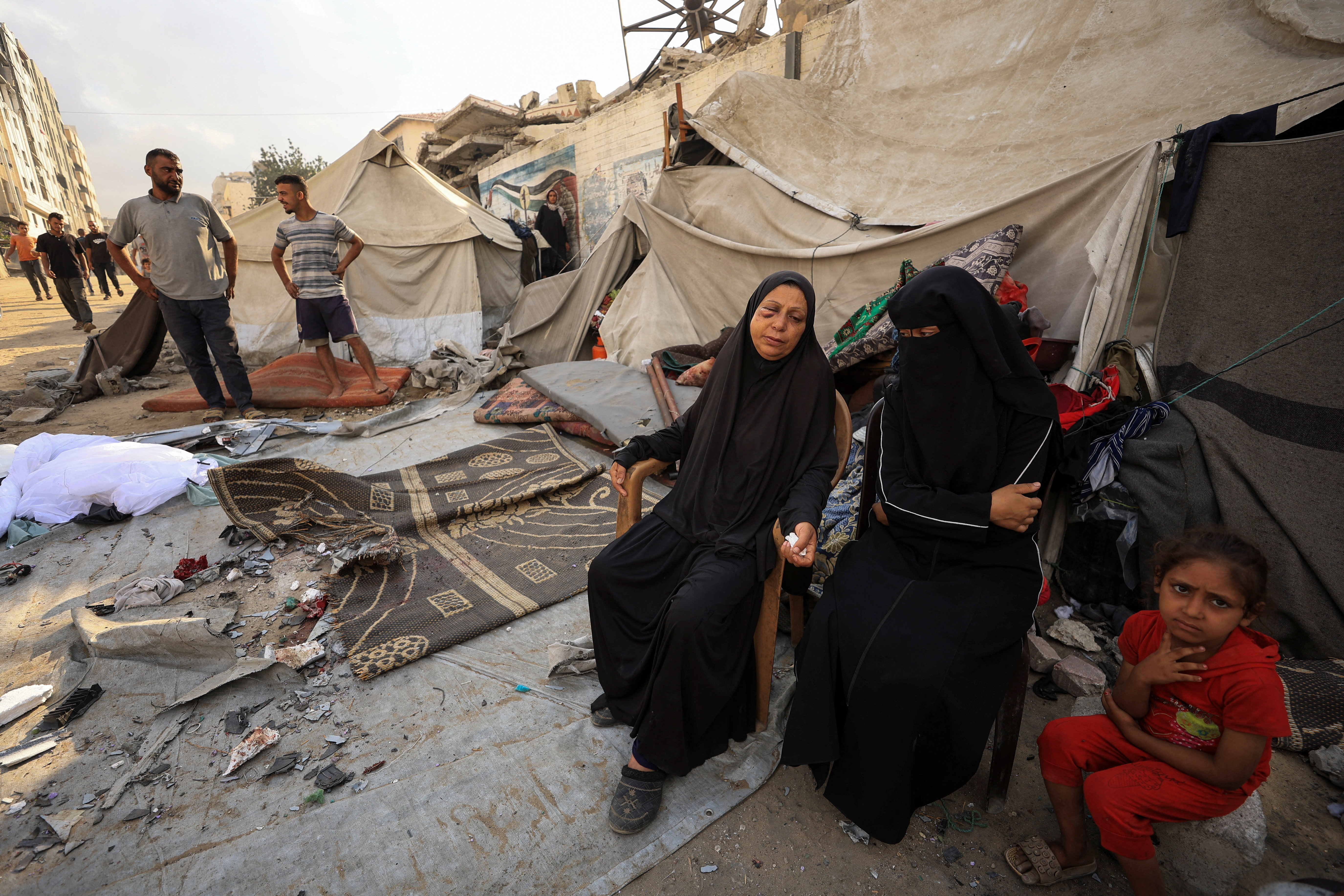 Palestinians inspect the site of an overnight Israeli strike on a tent, in Gaza City