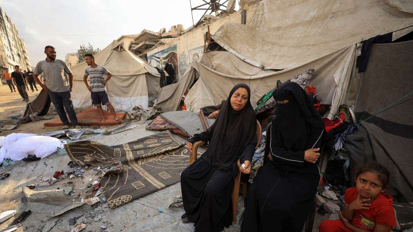 Palestinians inspect the site of an overnight Israeli strike on a tent, in Gaza City