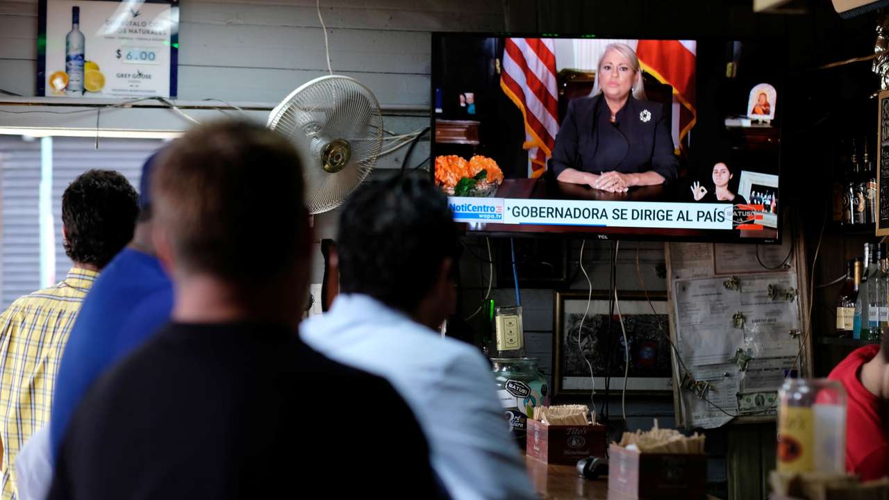 People watch television at a bar as Puerto Rico's Governor Wanda Vazquez Garced makes an address regarding the debt restructuring proposal filed in court by an oversight board, in San Juan