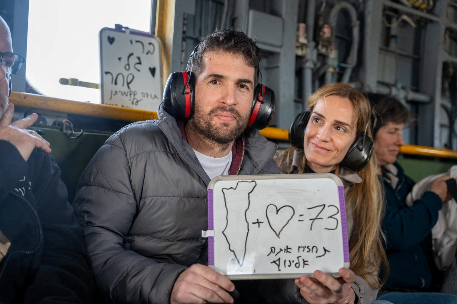 Released hostage, Sagui Dekel-Chen, who was seized during the deadly attack by Hamas, sits next to his wife as he flies to central Israel