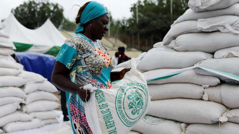 A woman receives a bag of food from the government during the distribution of food items by the government to cushion the high cost of living in Abuja