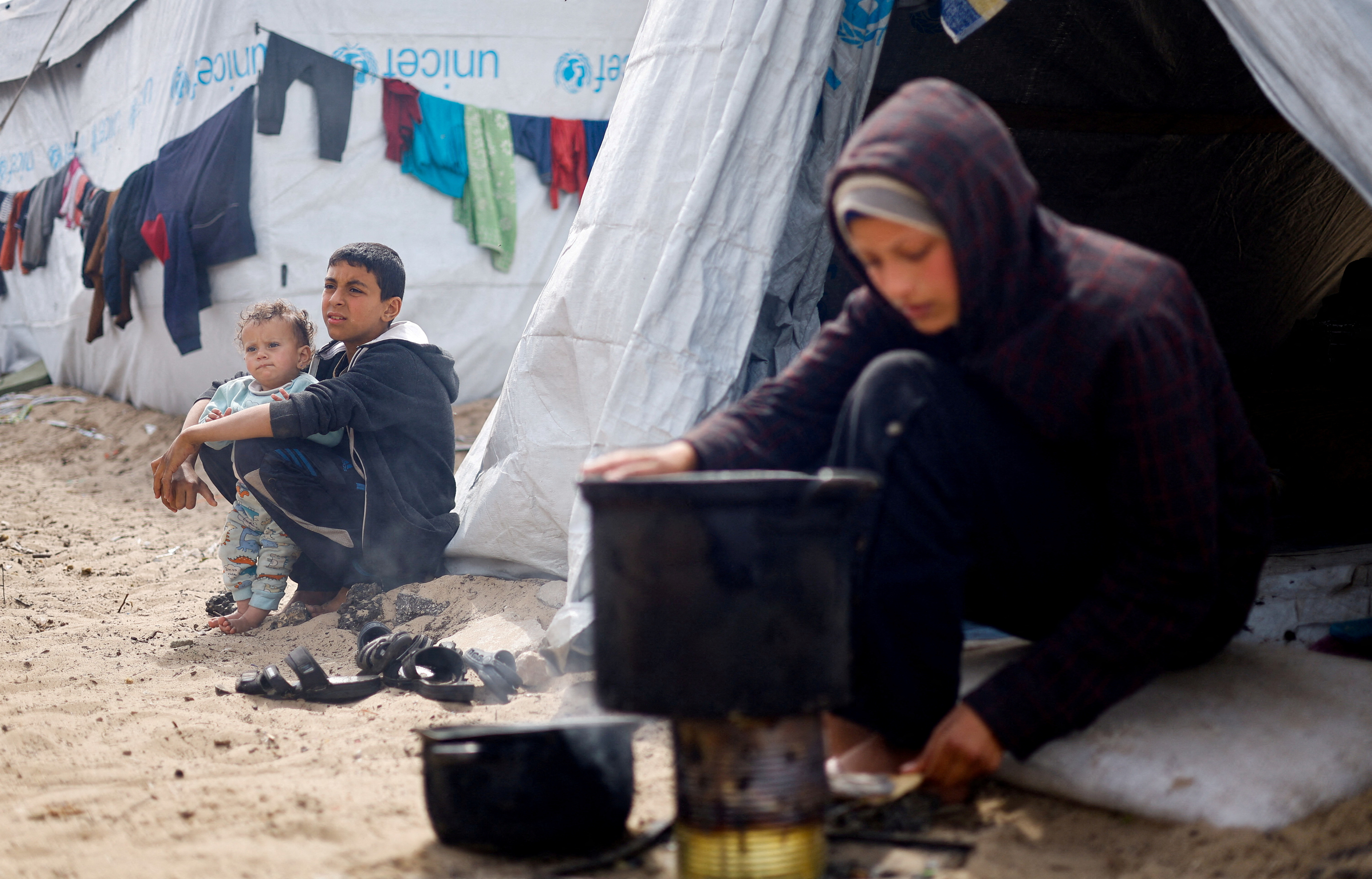 Displaced Palestinians, who fled their houses due to Israeli strikes, shelter at a tent camp, in Rafah