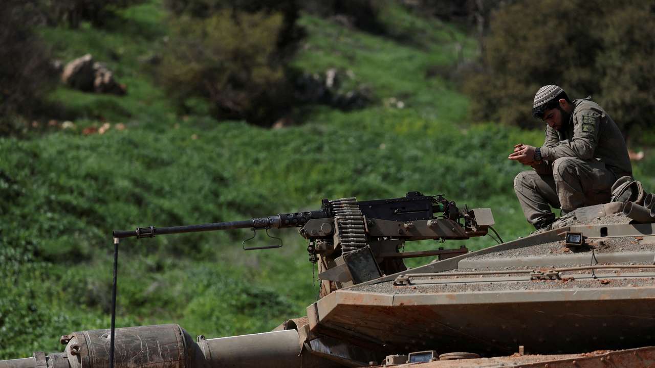 Israeli soldiers sit on a tank on the Israeli side of the border with Lebanon, amid escalation between Hezbollah and Israel