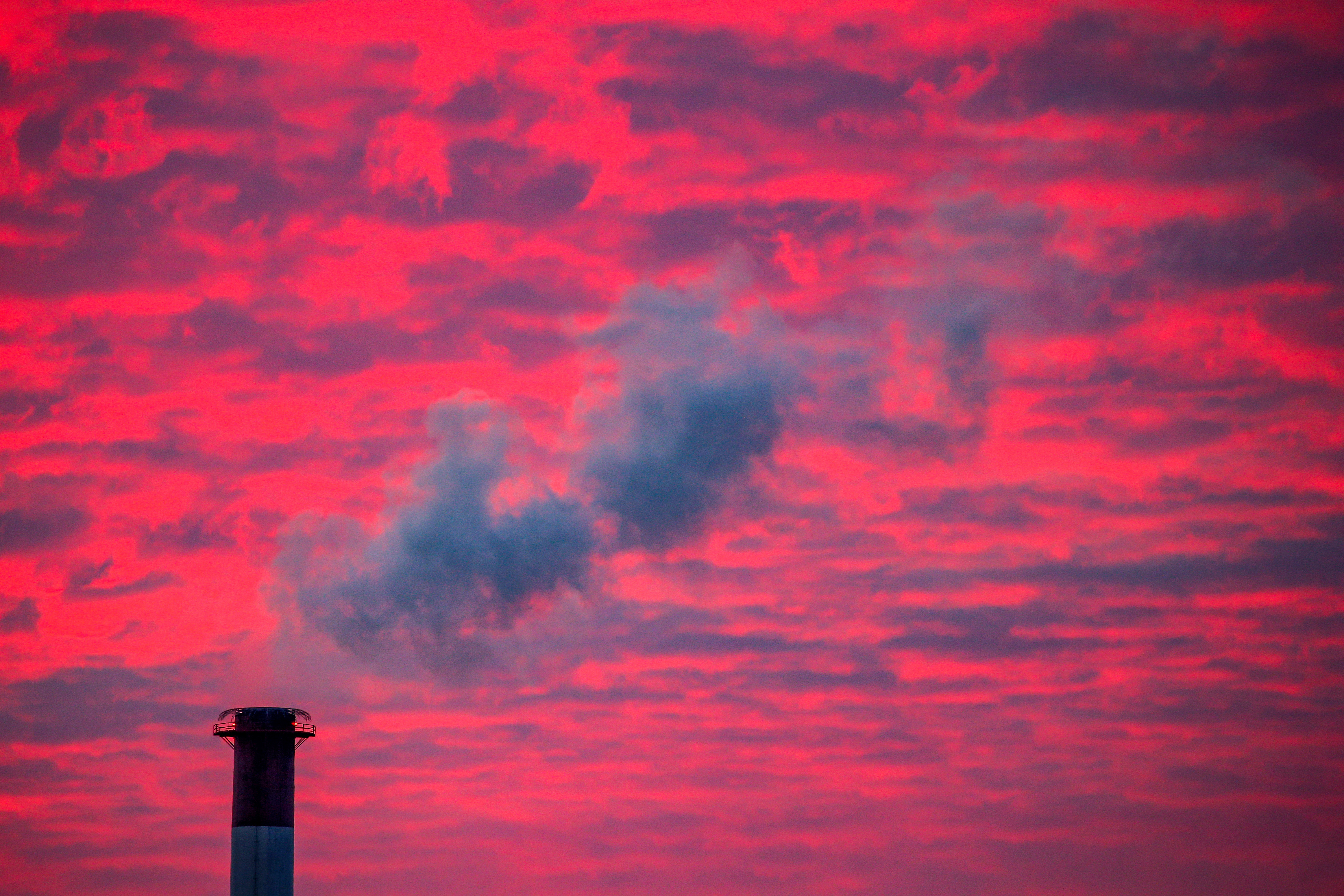 Steam rises from a smoke stack at sunset in Lansing, Michigan