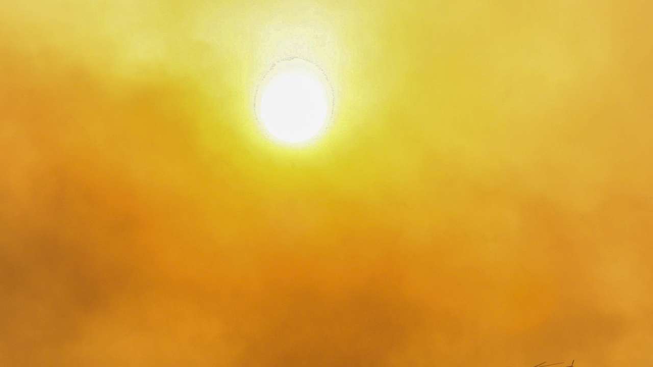 A firefighting helicopter flies through the smoke near Marmaris