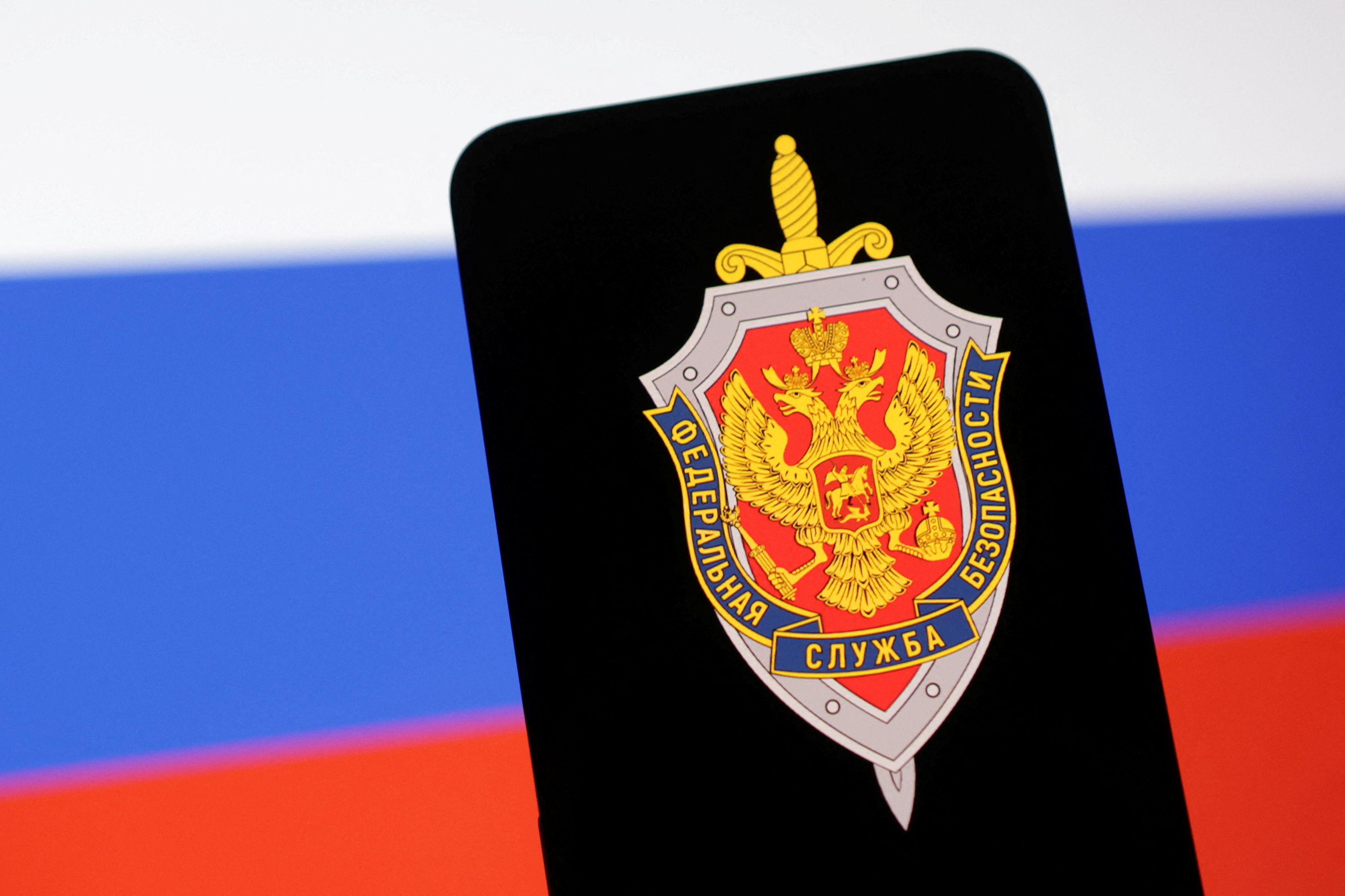 FILE PHOTO: Illustration shows FSB (Federal'naya Sluzhba Bezopasnosti) logo and Russian flag