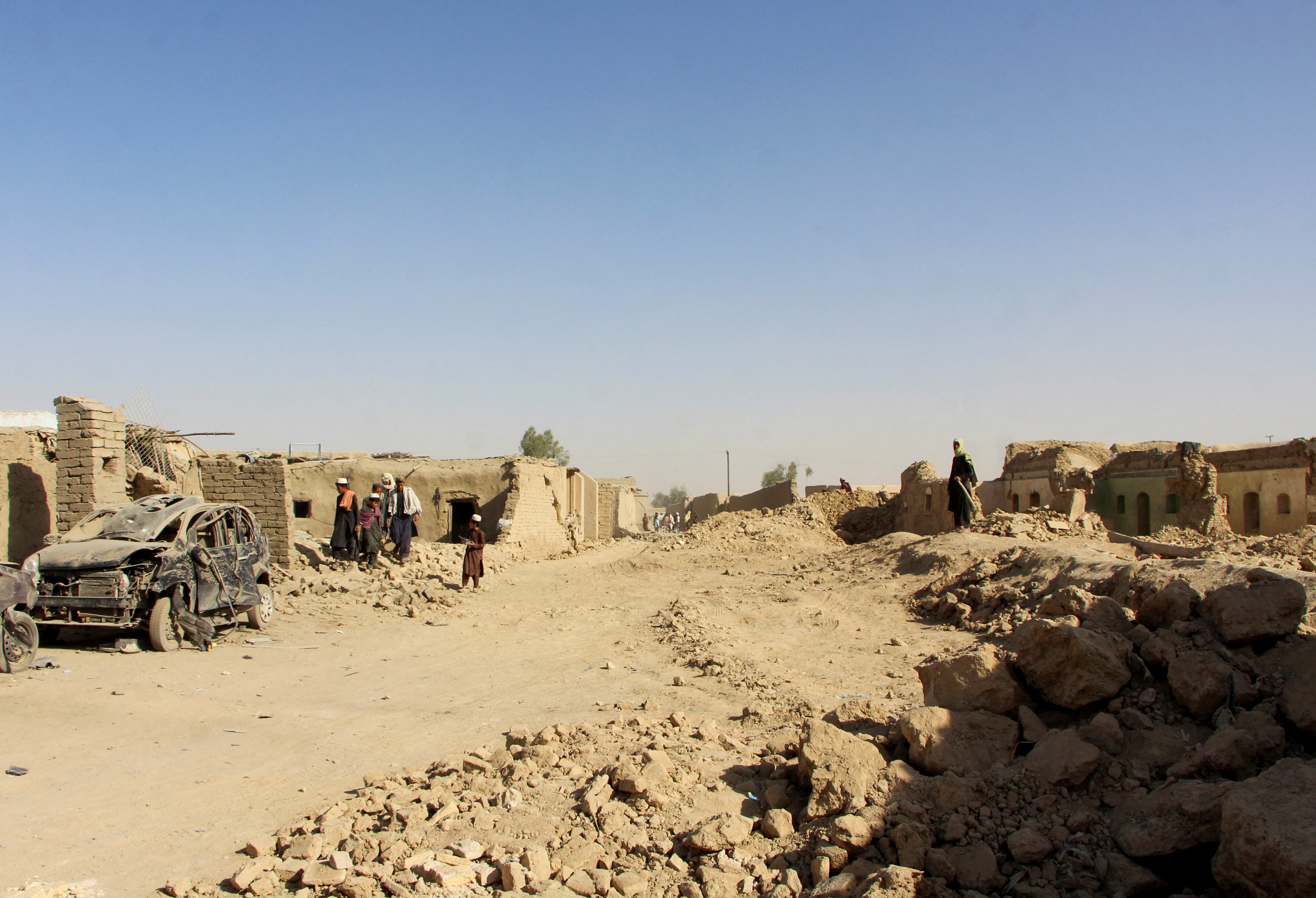 People inspect houses and vehicles destroyed during an airstrike following a temporary ceasefire amid the conflict between Afghanistan and Pakistan, in Spin Boldak