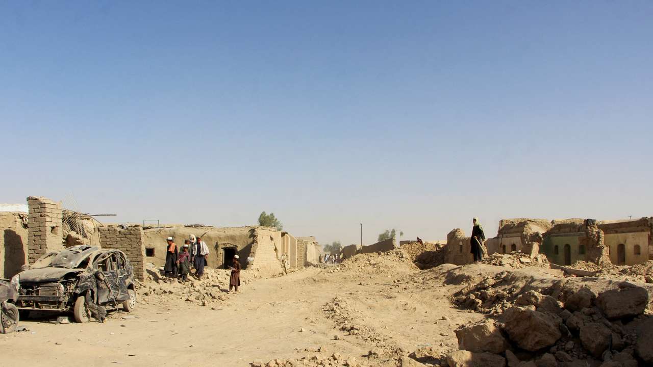 People inspect houses and vehicles destroyed during an airstrike following a temporary ceasefire amid the conflict between Afghanistan and Pakistan, in Spin Boldak