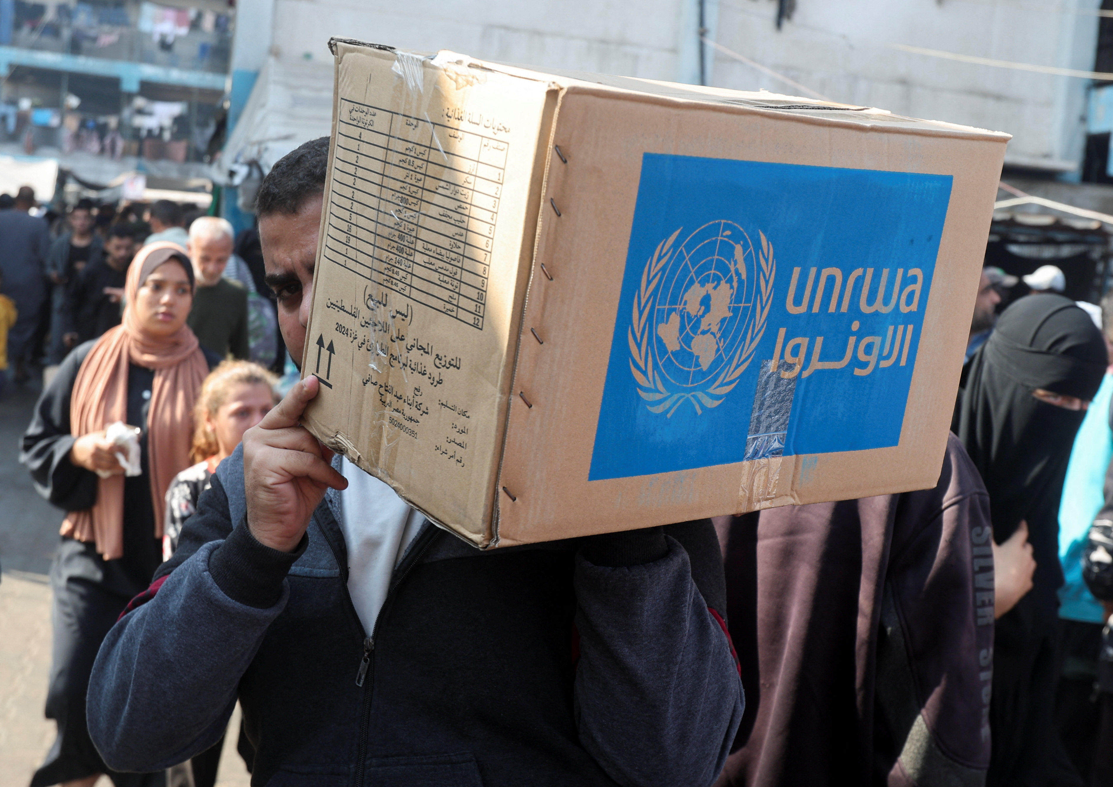 Palestinians receive aid from UNRWA in Deir Al-Balah, central Gaza Strip
