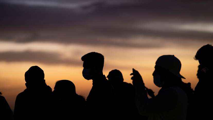People wearing face protective masks watch the sunset from Griffith Observatory during a partial lockdown during the outbreak of the coronavirus disease (COVID-19), in Los Angeles