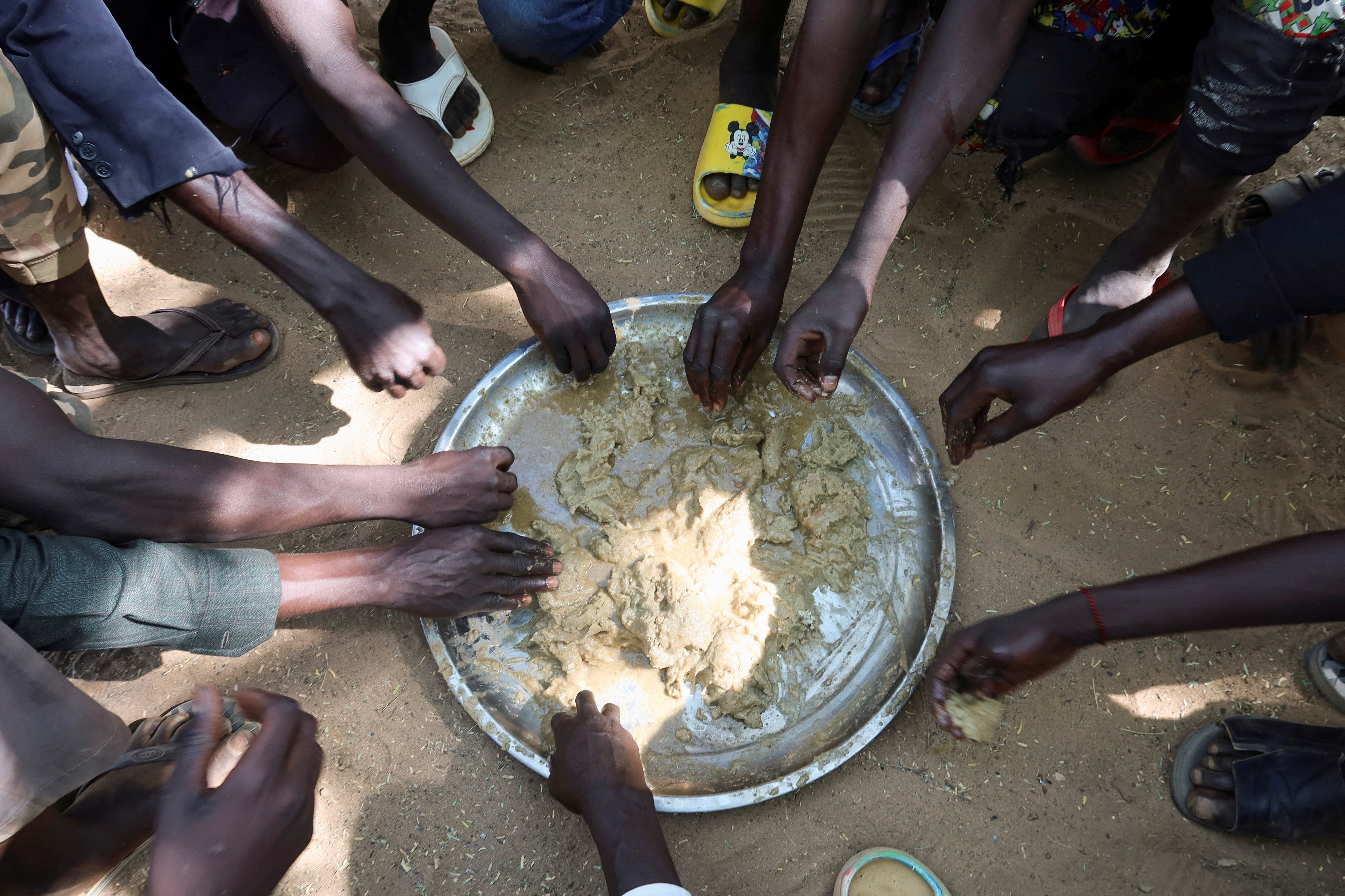 FILE PHOTO: Refugees eat food in the Adre Sudanese refugee camp in Adre
