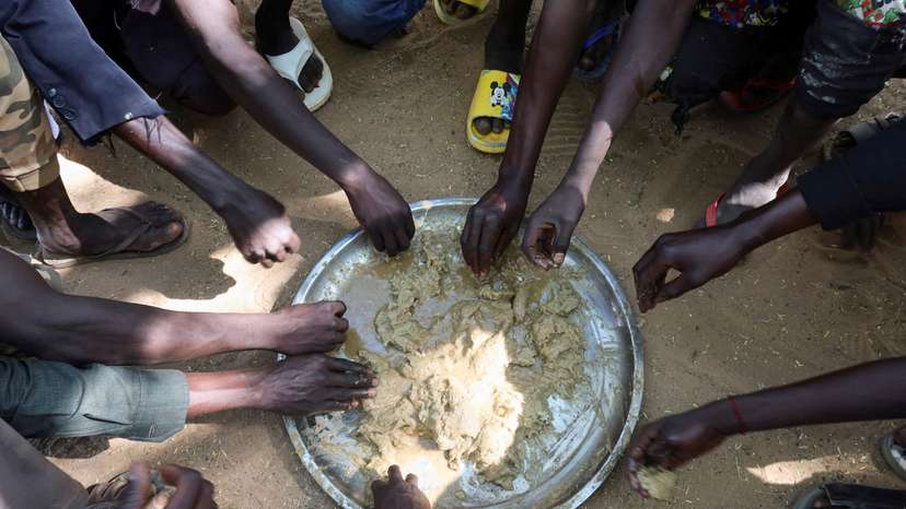 FILE PHOTO: Refugees eat food in the Adre Sudanese refugee camp in Adre