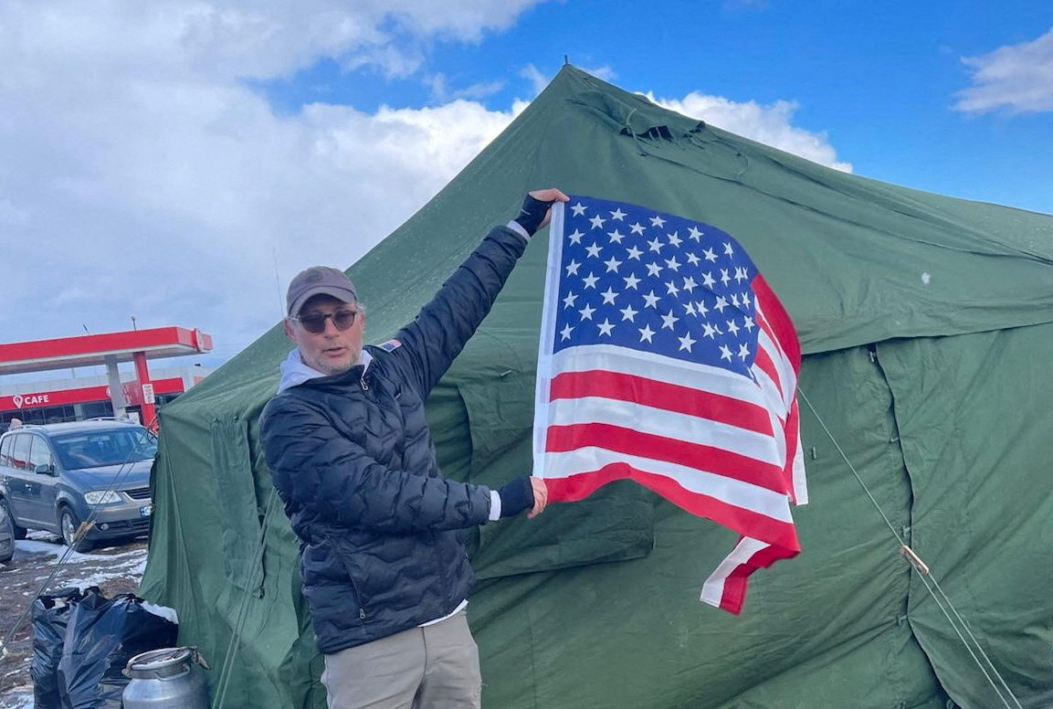 Israeli-American businessman Moti Kahana holds a flag during a mission to evacuate 200 Jews in Chernivtsi