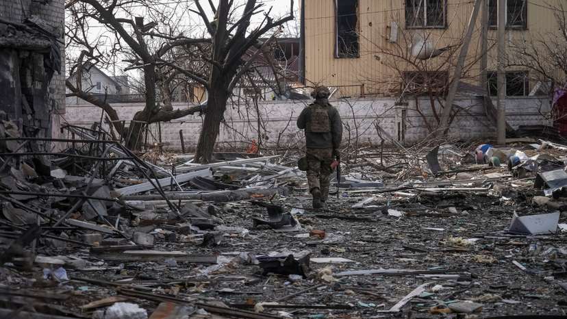A Ukrainian serviceman passes by buildings damaged by Russian military strikes in the frontline town of Pokrovsk