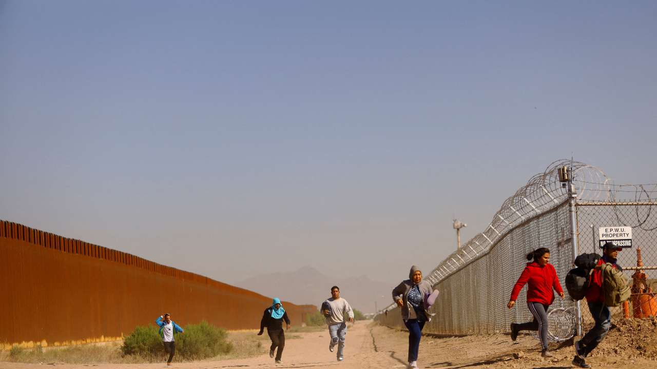 FILE PHOTO: Migrants run to hide from the U.S. Border Patrol and the Texas National Guard in El Paso