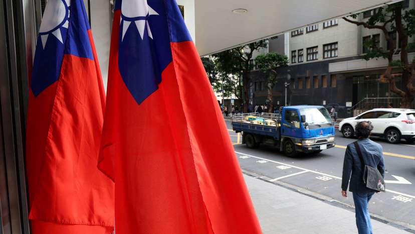 FILE PHOTO: A man walks past Taiwanese flags on a street in Taipei