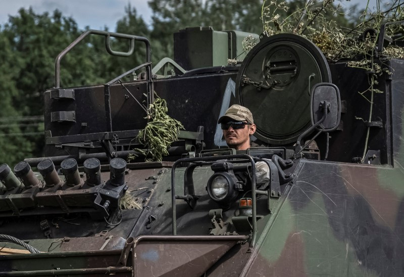 Ukrainian servicemen ride APC near the Russian border in Sumy region