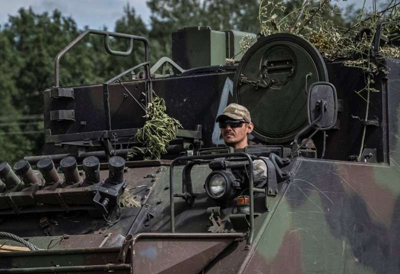 Ukrainian servicemen ride APC near the Russian border in Sumy region