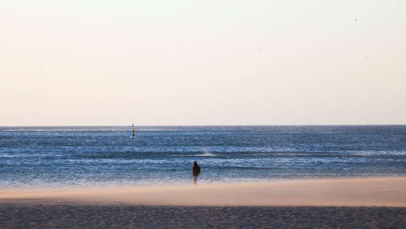 A woman walks on the Barceloneta beach during high winds in Barcelona