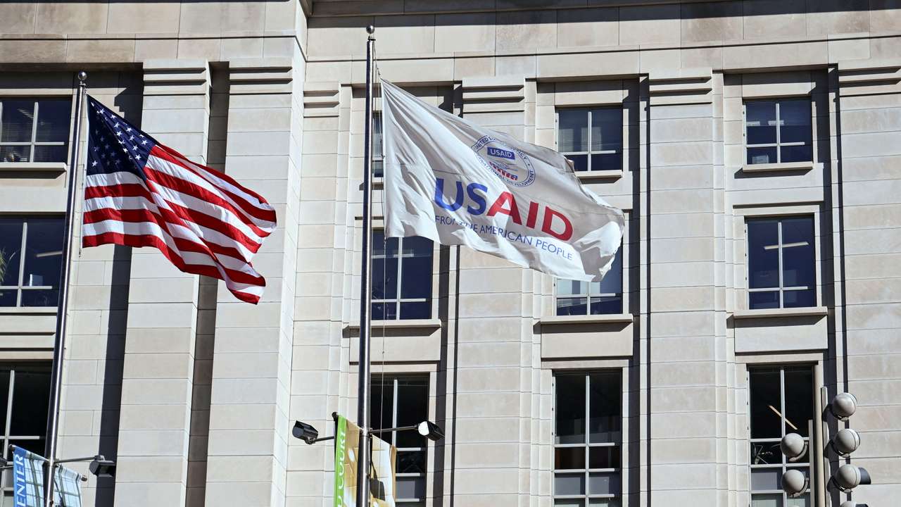 An American flag and USAID flag fly outside the USAID building in Washington