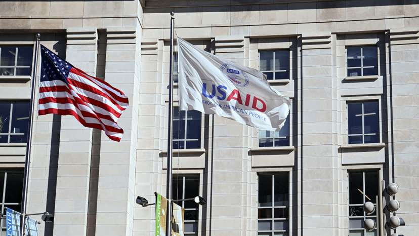 An American flag and USAID flag fly outside the USAID building in Washington