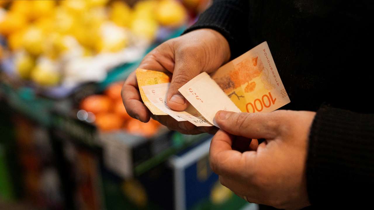 A greengrocer counts Argentine peso bills at a local market,as Argentina is due to release consumer inflation data for April, in Buenos Aires