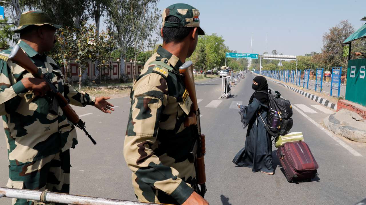 A woman crosses a Border Security Force (BSF) checkpoint at the Attari-Wagah crossing on the India-Pakistan border near Amritsar