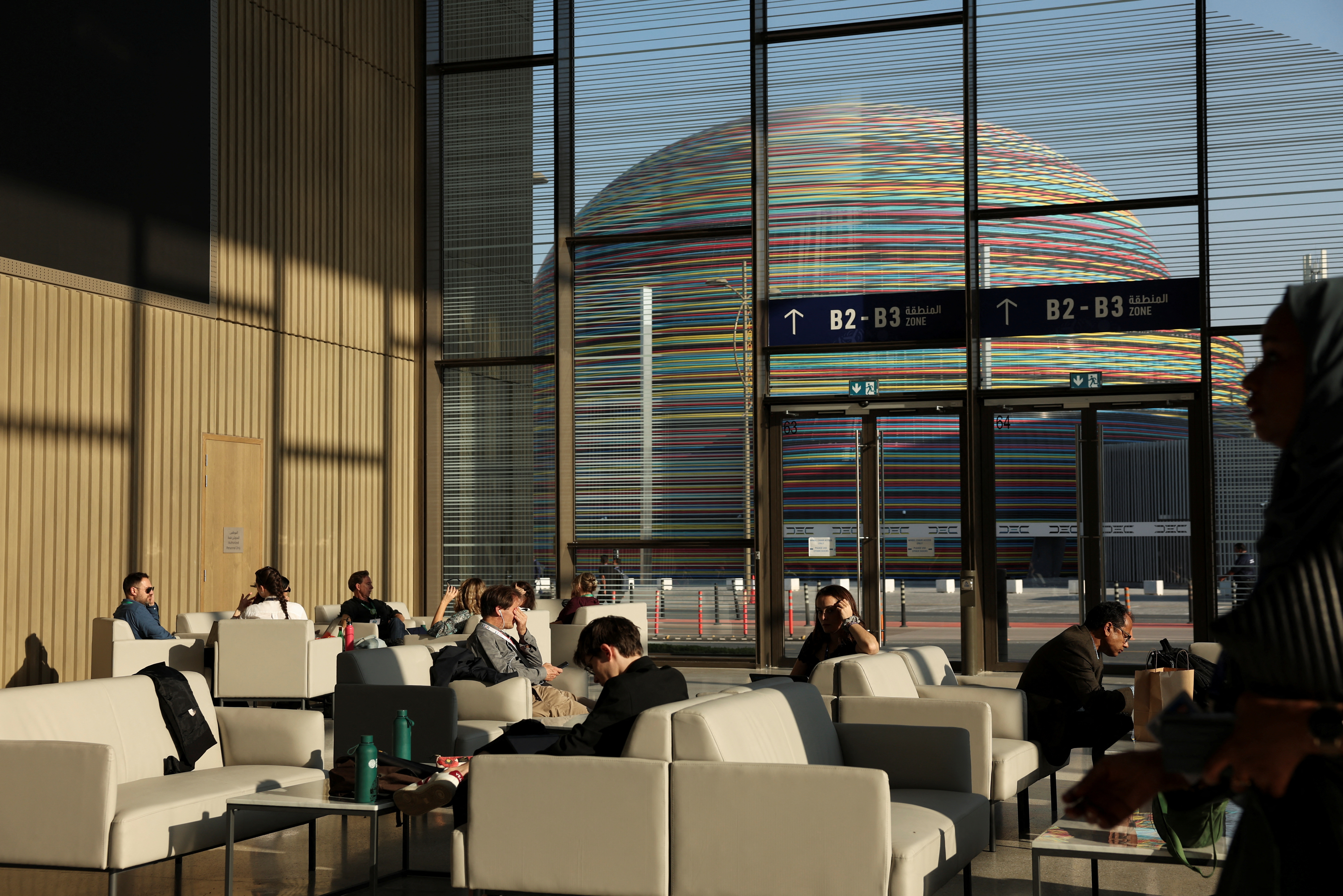 Attendees and delegates sit in a common area during COP28 in Dubai
