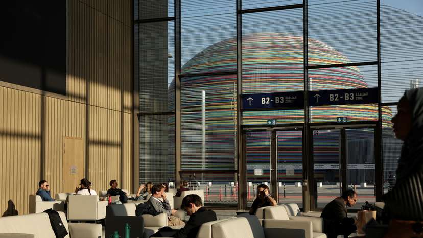 Attendees and delegates sit in a common area during COP28 in Dubai