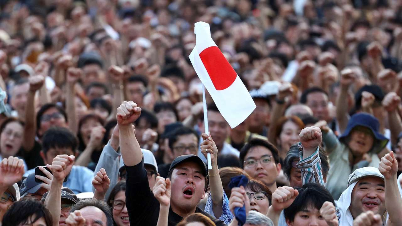 Sanseito party supporters raise their fists during the Sanseito's election campaign tour in Tokyo