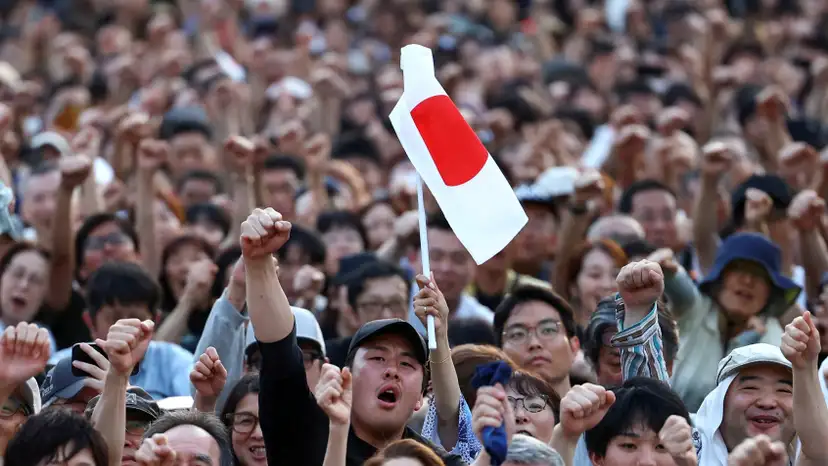 Sanseito party supporters raise their fists during the Sanseito's election campaign tour in Tokyo